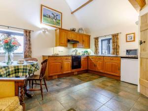 a kitchen with wooden cabinets and a table and a table and chairs at 1 Bed in Leighton oc-80726 in Leighton +7 photos