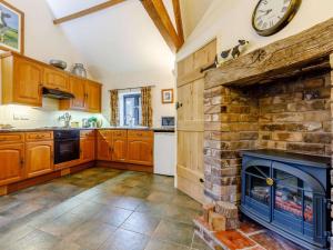 a kitchen with a fireplace and a clock on the wall at 1 Bed in Leighton oc-80726 in Leighton