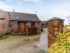 an old brick house with a gate in front of it at 1 Bed in Leighton oc-80726 in Leighton