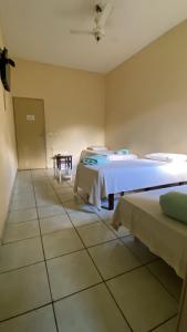 a room with two beds and a table in it at Império Hotel in Costa Rica