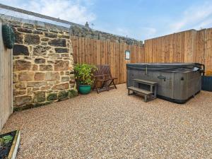 a patio with a fireplace and a wooden fence at 3 Bed in Morpeth oc-96236 in Amble