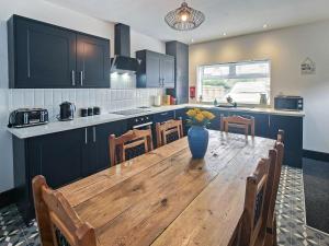 a kitchen with a wooden table with a vase on it at 3 Bed in Morpeth oc-96236 in Amble