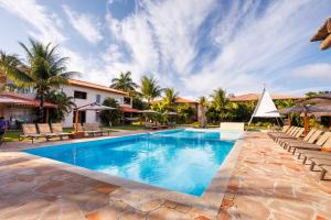 a swimming pool with lounge chairs and a resort at La Torre Resort All Inclusive in Porto Seguro