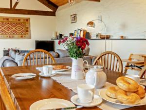 a wooden table with plates of food and flowers on it at 2 Bed in Dulverton oc-90558 in Dulverton