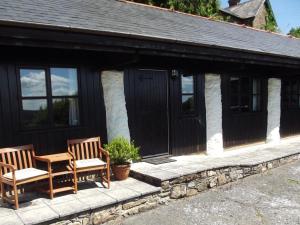 two chairs and a table in front of a cottage at 2 Bed in Dulverton oc-90558 in Dulverton