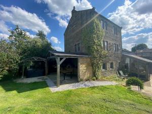 an ivy covered building with a covered patio at 6 Bed in Huddersfield oc-93984 in Huddersfield