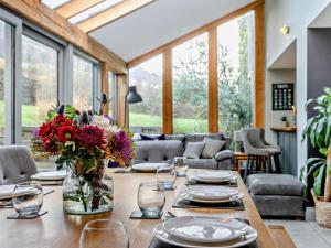 a dining room with a table with a vase of flowers at 6 Bed in Huddersfield oc-93984 in Huddersfield
