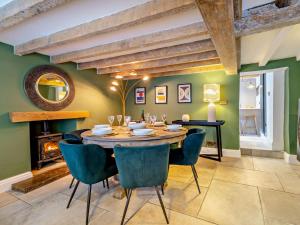 a dining room with a table and chairs and a fireplace at 3 Bed in Warwick oc-93887 in Kineton