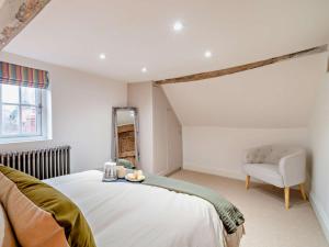 a bedroom with a bed and a chair and a mirror at 3 Bed in Warwick oc-93887 in Kineton