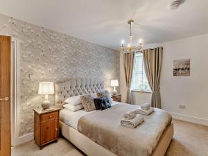 a bedroom with a large bed and a wall with flowers at 2 Bed in Morpeth oc-91206 in Amble