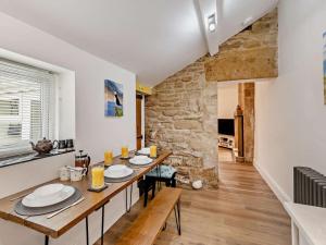 a dining room with a table and a stone wall at 2 Bed in Morpeth oc-91206 in Amble