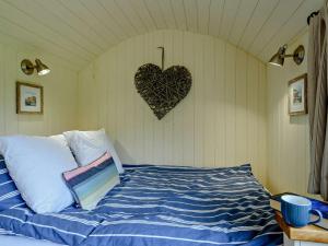 a bedroom with a bed with a heart on the wall at 1 Bed in Hereford oc-93440 in Little Dewchurch +12 photos
