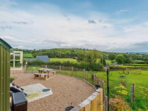 a patio with a picnic table and a fence at 1 Bed in Hereford oc-93440 in Little Dewchurch