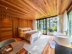 a bedroom with a bed and a tub in it at Mökki Cabanas de Altitude INAUGURAÇÃO ABRIL 2026 in Urubici