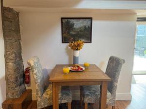 a dining room table with chairs and a bowl of fruit at 1 Bed in Buxton oc-58958 in Flash +8 photos