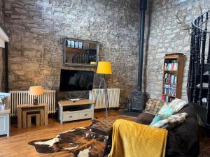a living room with a stone wall at 1 Bed in Buxton oc-58958 in Flash