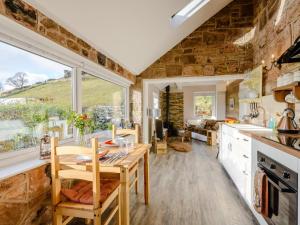 a kitchen with a wooden table and a large window at 1 Bed in Buxton oc-74351 in Flash