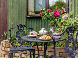a table with a plate of bread and a vase of flowers at 1 Bed in Shrewsbury oc-80587 in Leighton +8 photos