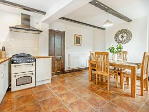 a kitchen and dining room with a table and a stove at 2 Bed in Oswestry oc-76537 in Gobowen