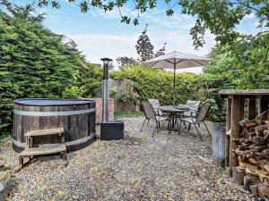 a patio with a table and an umbrella and a wooden barrel at 2 Bed in Oswestry oc-76537 in Gobowen