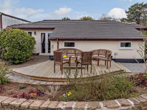 three chairs and a table on a wooden deck at 3 Bed in Monmouth oc-52149 in Welsh Newton Common