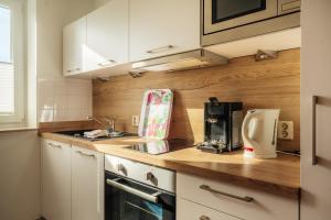 a kitchen with white cabinets and a counter top at Klippenblick in Schierke +12 photos