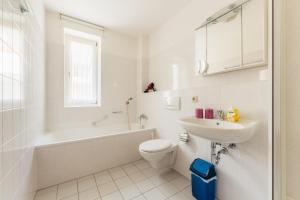 a white bathroom with a toilet and a sink at Klippenblick in Schierke