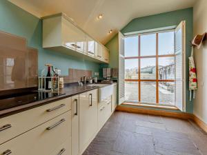 a kitchen with white cabinets and a large window at 3 Bed in Ludlow oc-chl38 in Ashford Carbonell