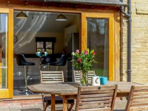 a wooden table with a vase of flowers on it at 2 Bed in Ludlow oc-59293 in Lane to Richards Castle
