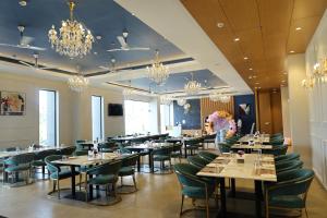 a dining room with tables and chairs and chandeliers at Manratan Resort in Narsinghgarh