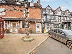 a car parked in front of a building with a tree at 1 Bed in Kidderminster oc-82957 in Cleobury Mortimer