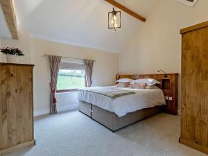 a bedroom with a large bed and a window at 5 Bed in Leek oc-79543 in Grindon