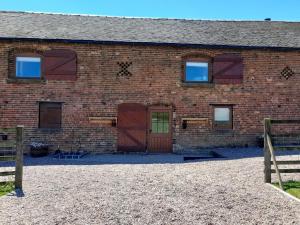 a brick building with two doors and a barn at 5 Bed in Leek oc-79543 in Grindon