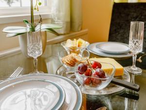 a table with plates and bowls of fruit on it at 1 Bed in Cinderford oc-88272 in Cinderford +4 photos