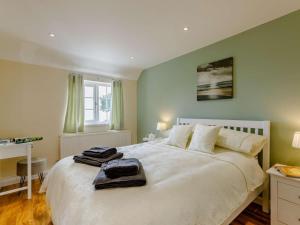 a bedroom with a white bed with two towels on it at 1 Bed in Cinderford oc-88272 in Cinderford