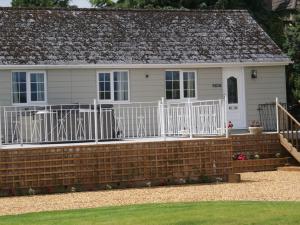 a house with a brick retaining wall and a white fence at 1 Bed in Cinderford oc-88272 in Cinderford