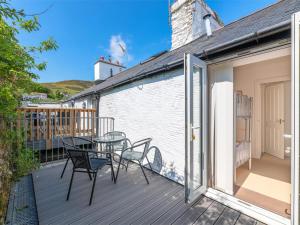 a patio with a table and chairs on a deck at 2 Bed in Aberdyfi oc-dy047 in Aberdyfi