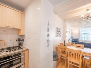 a kitchen with a stove and a table with chairs at 2 Bed in Aberdyfi oc-dy047 in Aberdyfi