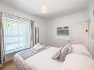 a white bedroom with a large bed with pillows at 2 Bed in Aberdyfi oc-dy047 in Aberdyfi