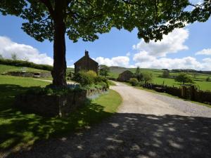 a road leading to a house with a tree at 2 Bed in High Peak oc-pk551 in Hayfield