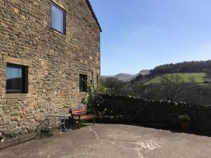 a stone building with a bench and a table outside at 2 Bed in High Peak oc-pk551 in Hayfield +12 photos