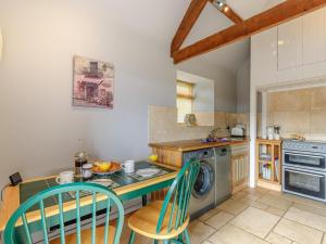 a kitchen with a counter with chairs and a washer at 1 Bed in Wotton -under- Edge oc-earba in Charfield