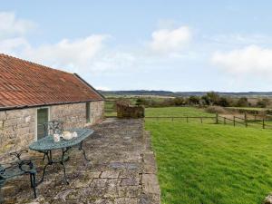 a stone cottage with a table and a field at 1 Bed in Wotton -under- Edge oc-earba in Charfield +7 photos