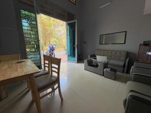 a living room with a table and a couch at Wheelezz in Kep