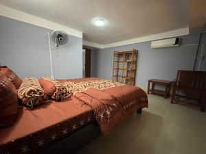 a bedroom with a bed and a fan at Wheelezz in Kep