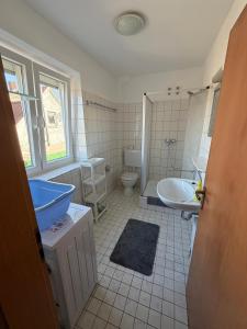 a bathroom with a tub and a toilet and a sink at Deichnest in Hollern-Twielenfleth