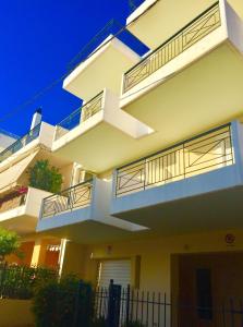 a white house with balconies and a fence at Kalamata Flats in Kalamata