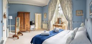 a blue bedroom with a bed and a window at Dalvey House in Forres +24 photos