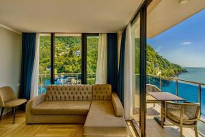 a living room with a couch and a view of the ocean at Panorama Kvariati in Kvariati