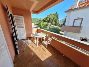 a balcony with a table and chairs on a building at Apartmani Štefica in Razvala